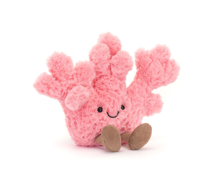 Pink plush coral toy with a smiling face on a white background