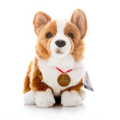 A plush toy corgi dog with a red collar and a gold Britannia medal, resembling a real corgi with a fluffy coat and pointed ears.